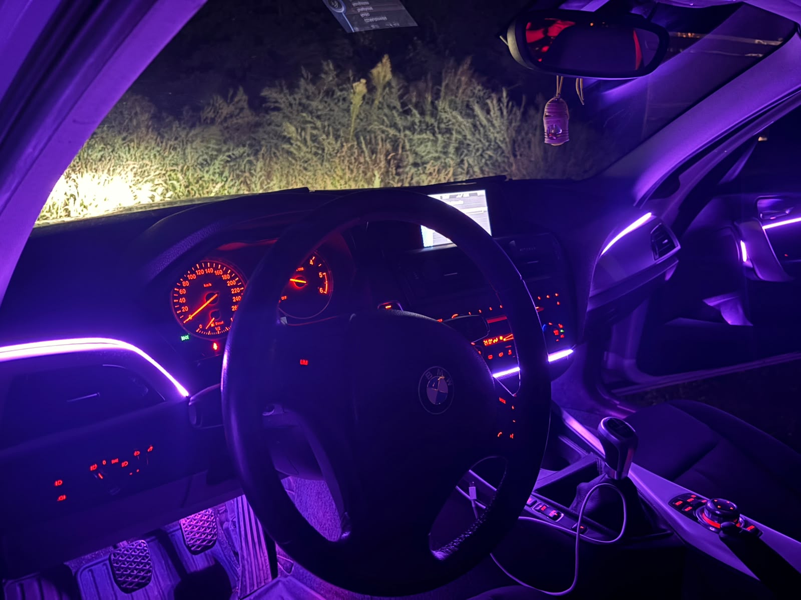 Purple ambient lighting across a BMW dashboard